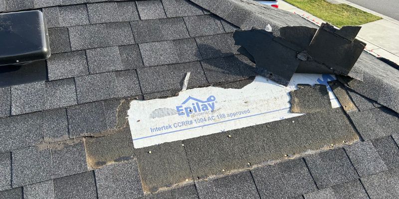 Storm-damaged shingles with exposed underlayment